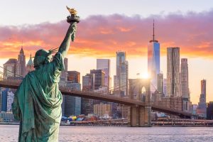 USA Statue Liberty and New York city skyline at sunset